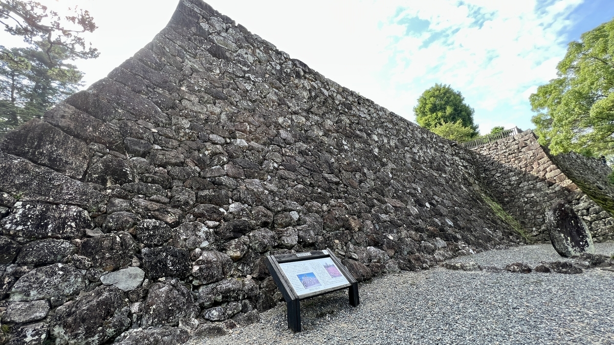 高知城三の丸にある高く積み上げられた石垣と、その前にある説明板