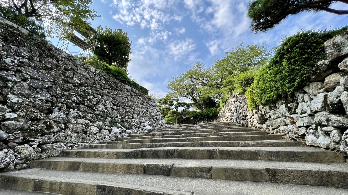 本丸手前の石垣に囲まれた石段。先に緑と空が広がっている