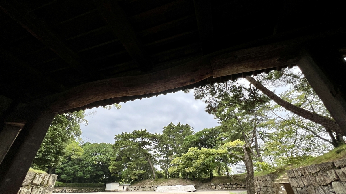 大手一ノ門の内側から外を望む風景。門の影越しに広がる緑と敷地