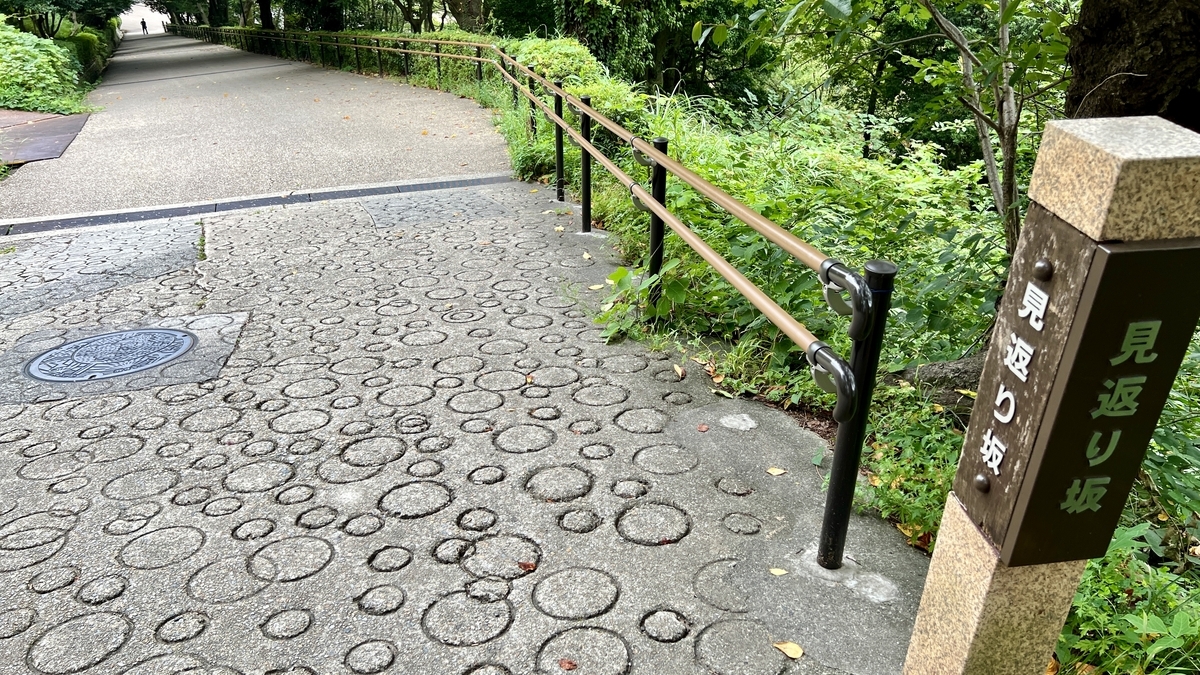 「見返り坂」の案内標柱と坂道の石畳。歴史を感じる城内の名所