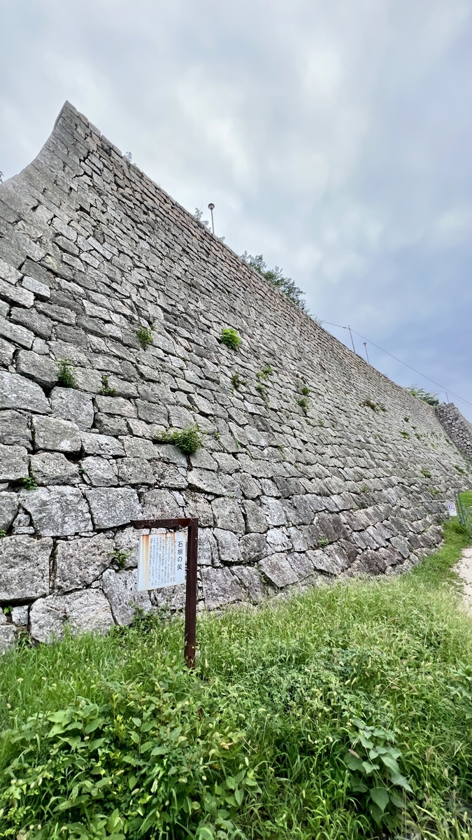 巨大な石垣が緑に映える風景。滑らかな曲面が際立つ設計美