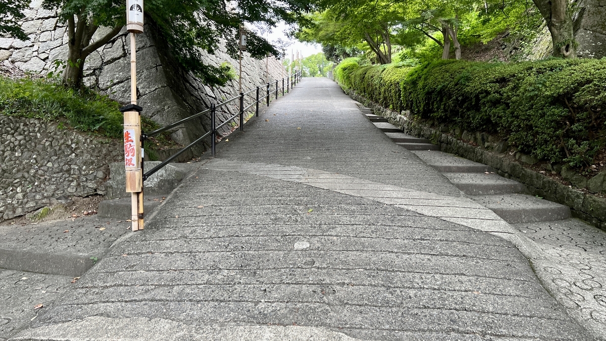 後半の見返り坂を進む石畳の坂道。両脇を緑が包み、静かな雰囲気