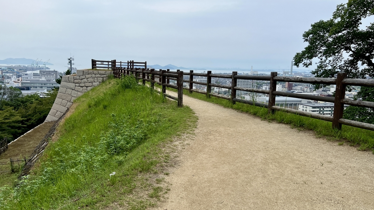 柵の奥に広がる丸亀市街の風景。三の丸広場の縁から見える絶景