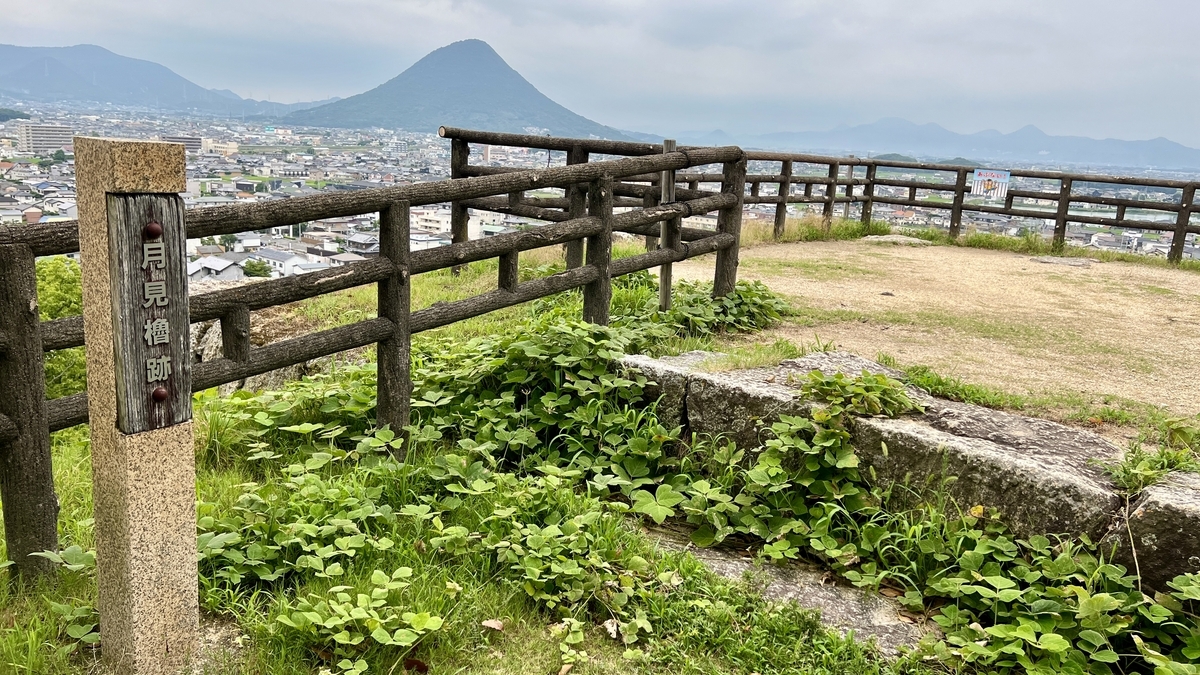 月見櫓跡の草地と展望柵。正面に飯野山が見える静かな展望スポット
