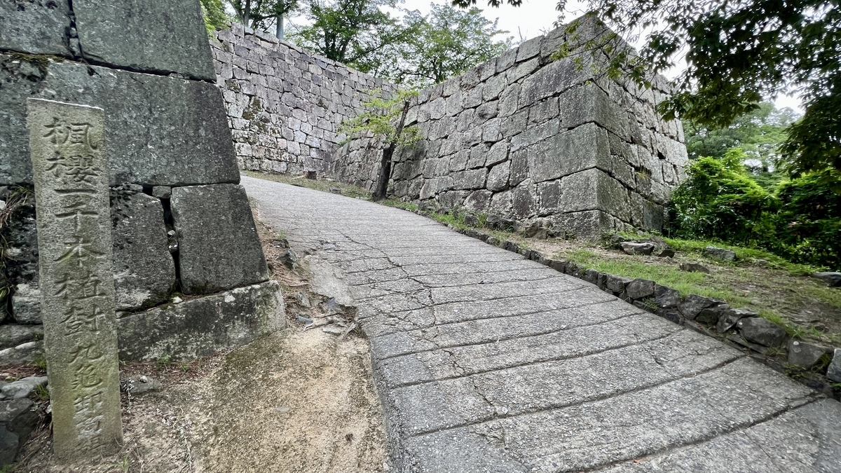 石垣沿いに伸びる舗装された上り坂。天守へのアクセスルートの一部
