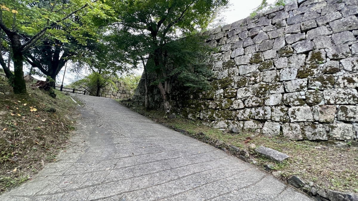 木陰と石垣の間を抜ける上り坂。天守直前の静かな通路