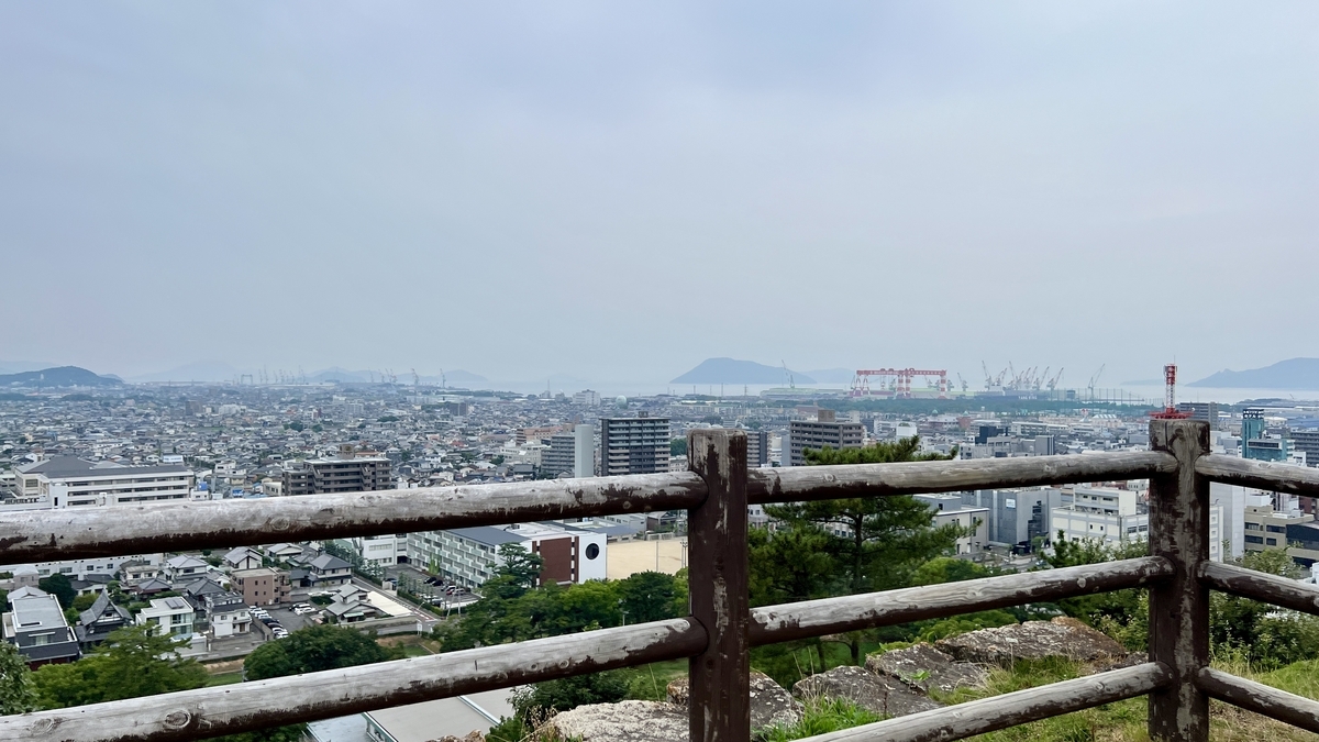 木製柵越しに広がる丸亀市街の様子。高台からの開放感あふれる風景