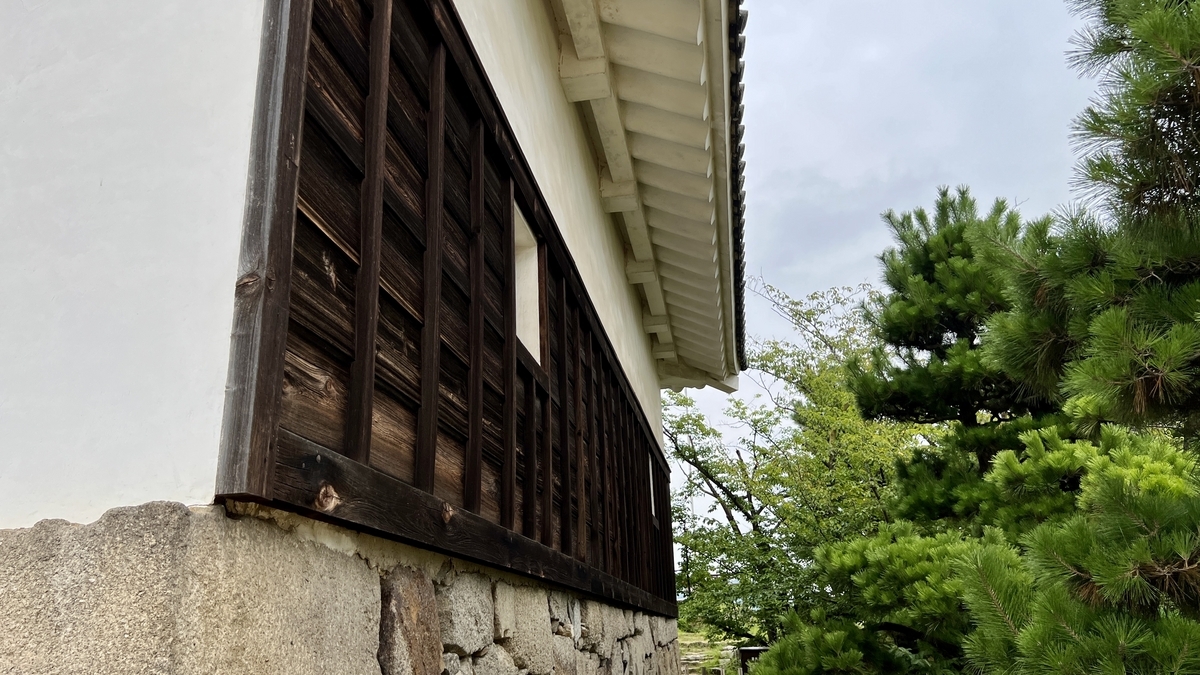 木製の格子窓と白壁が見える天守の側面。歴史を感じさせる外観