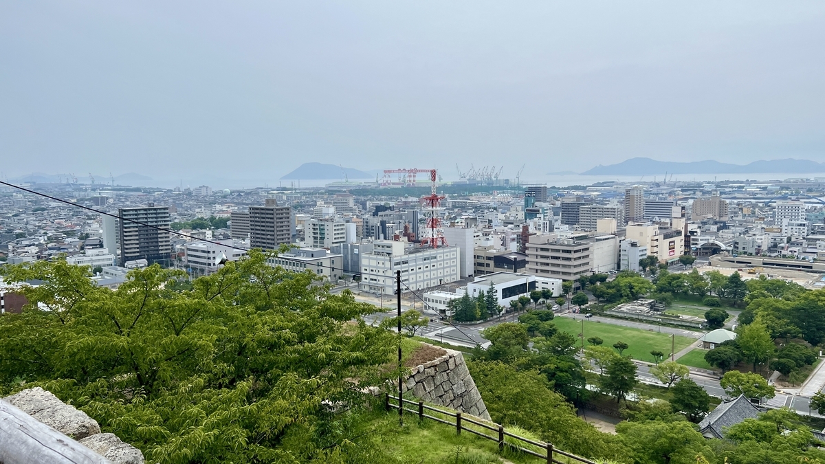 天守背後から見渡す丸亀市街の景色。街並みと遠くの山々が一望できる
