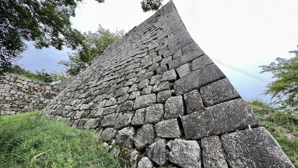 丸亀城の高石垣を斜め下から見上げた構図。扇の勾配と呼ばれる曲線が印象的