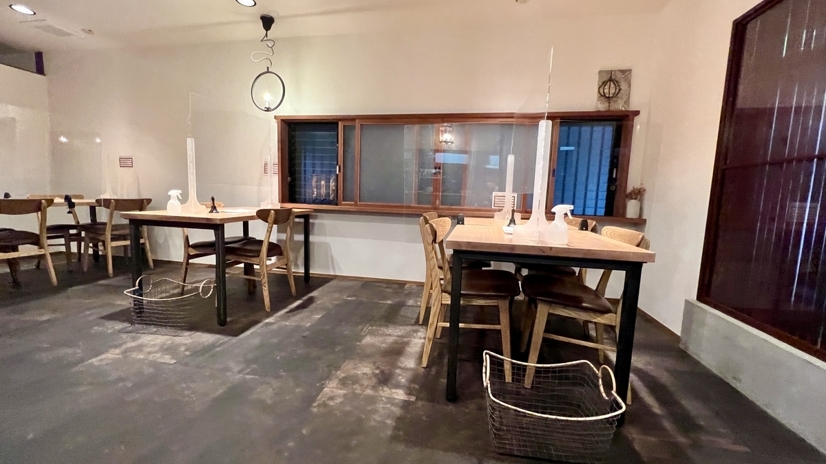 木のテーブルと椅子が並ぶ落ち着いた店内の様子