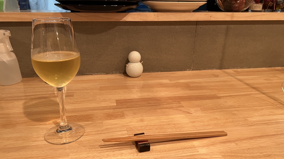 ワイングラスと箸が置かれたカウンター席の一角