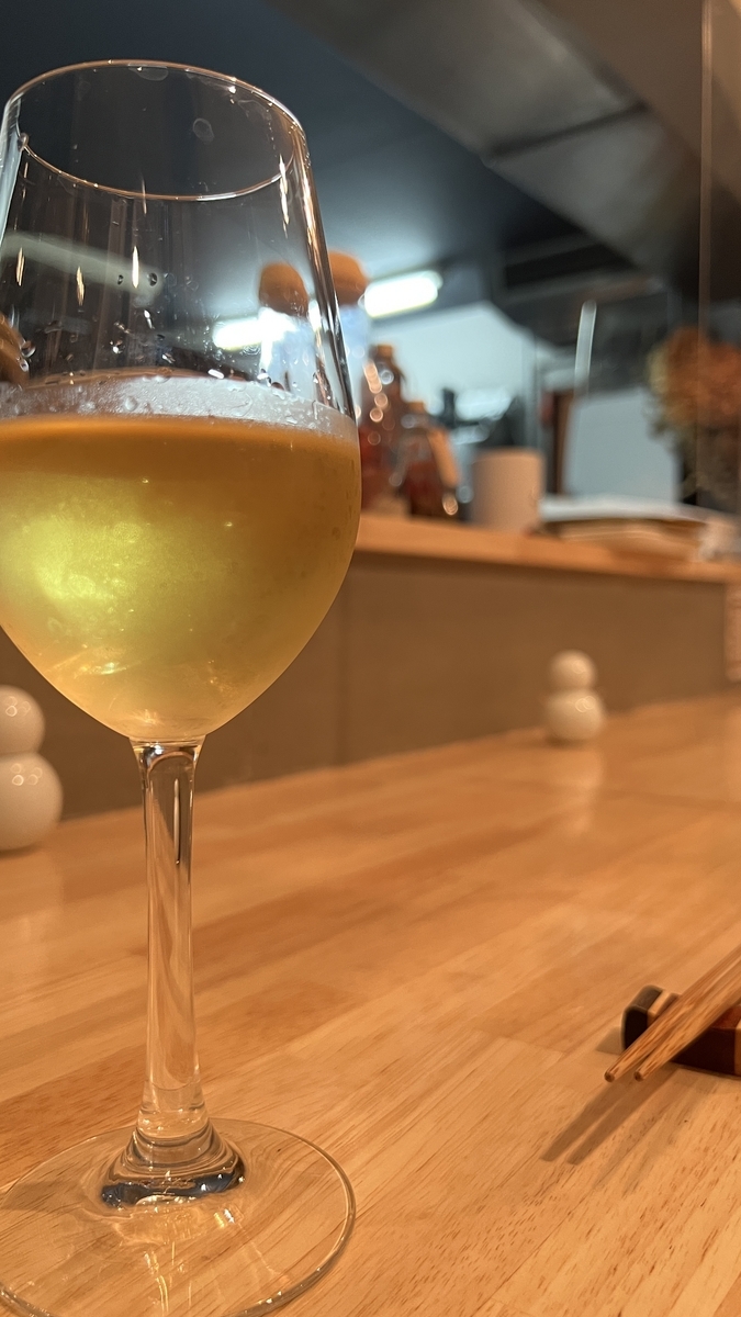 ワインを注いだグラスと奥に厨房が見えるカウンター席