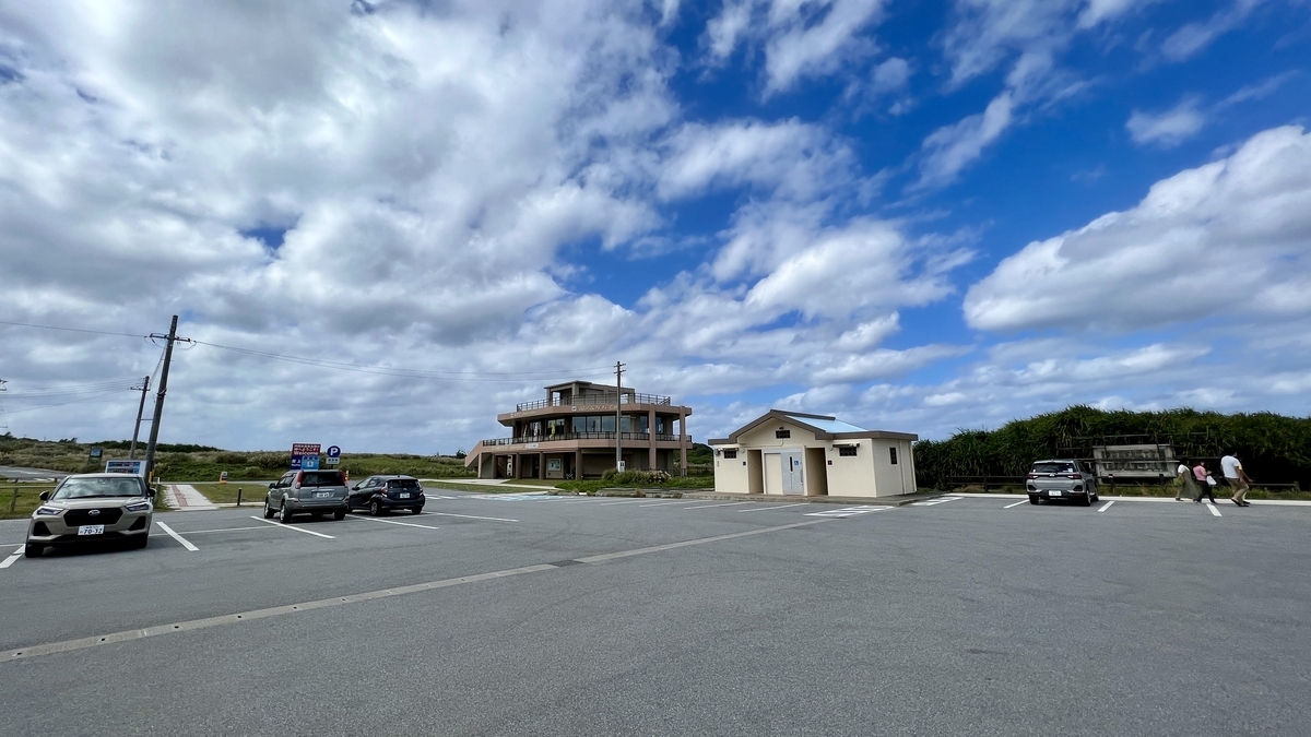 駐車場に隣接する観光案内所と白い建物のトイレ