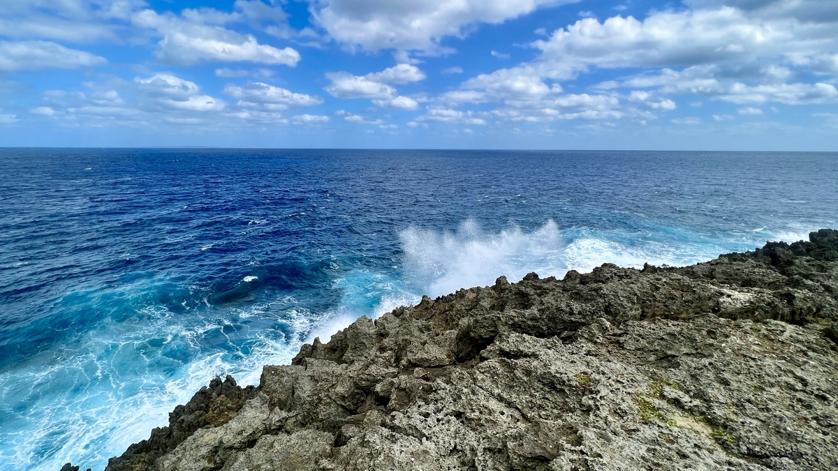 波しぶきが上がる岩場と真っ青な海のコントラスト