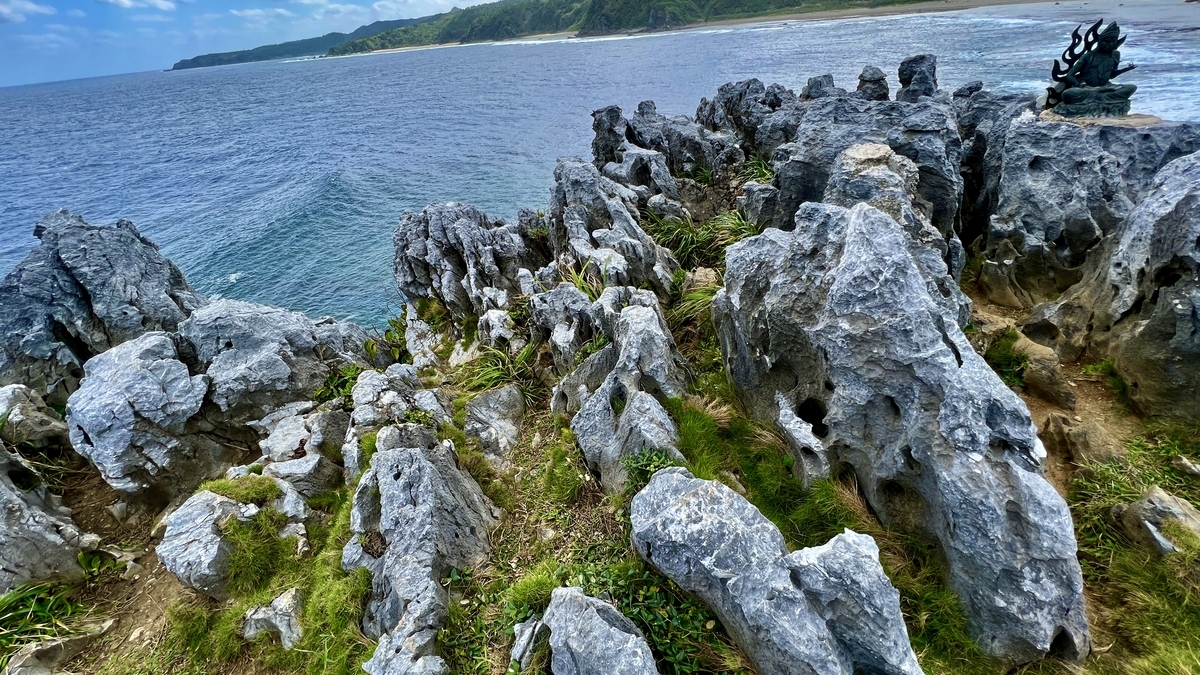 崖の上から眺める岩場と青い海の広がり