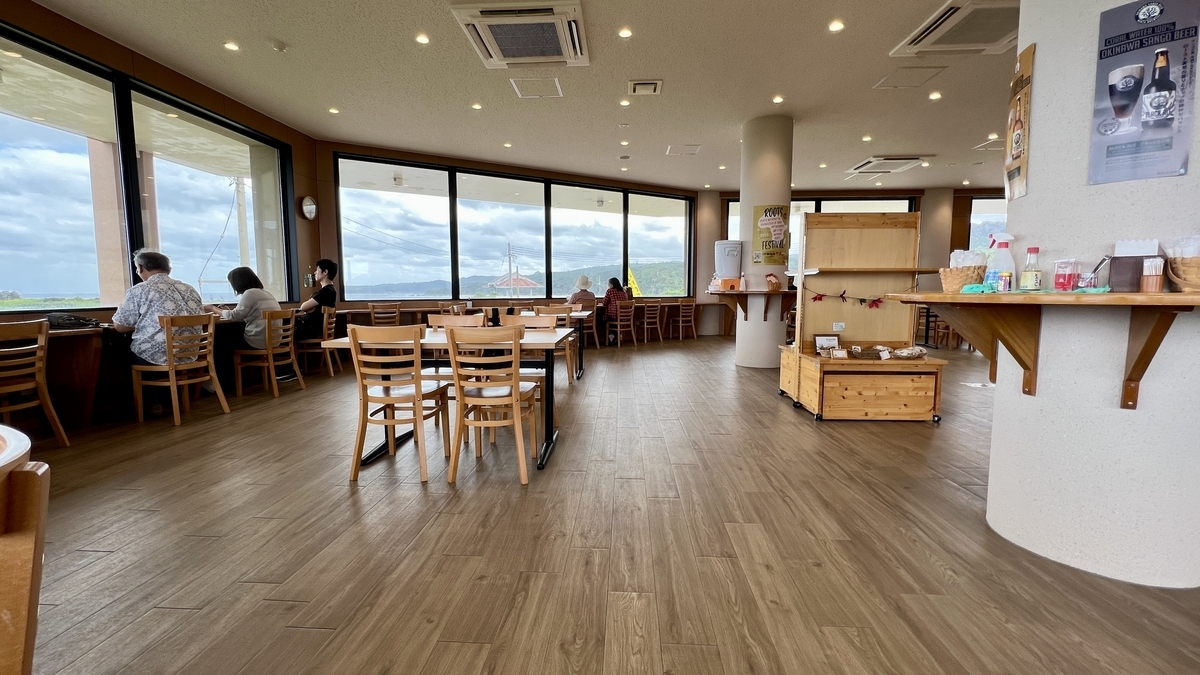 大きな窓から海を望めるふしくぶカフェの明るい店内