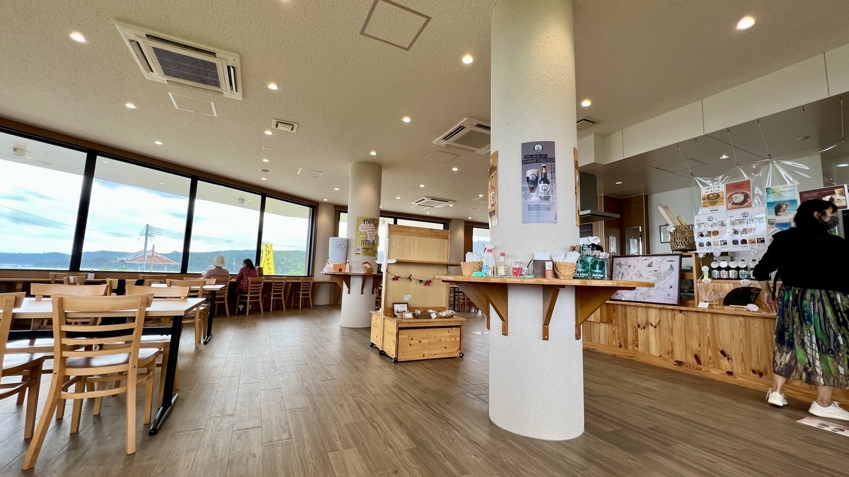 木の温もりを感じるカウンターとテーブル席が並ぶカフェ店内