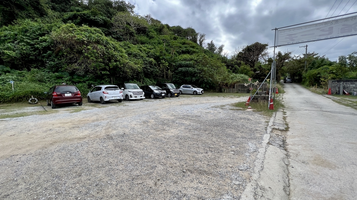 大泊ビーチ入口脇の駐車場に並ぶ車の様子 緑に囲まれた敷地