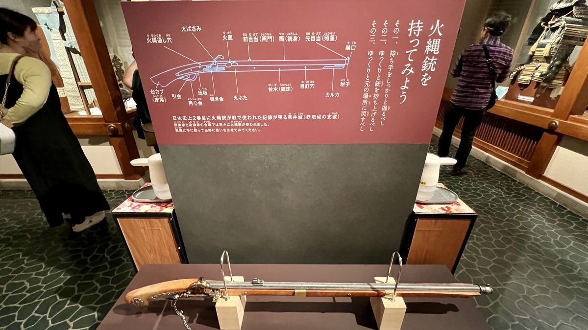 火縄銃の体験展示と台に置かれた火縄銃の説明