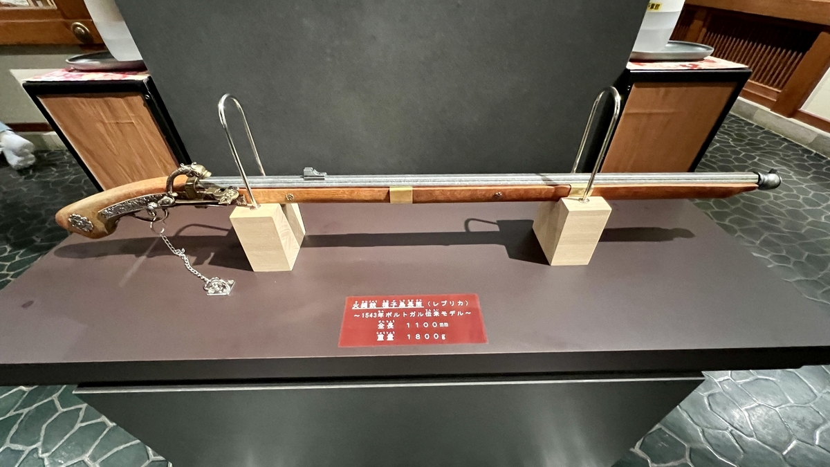 展示台に置かれた火縄銃と背景の体験案内