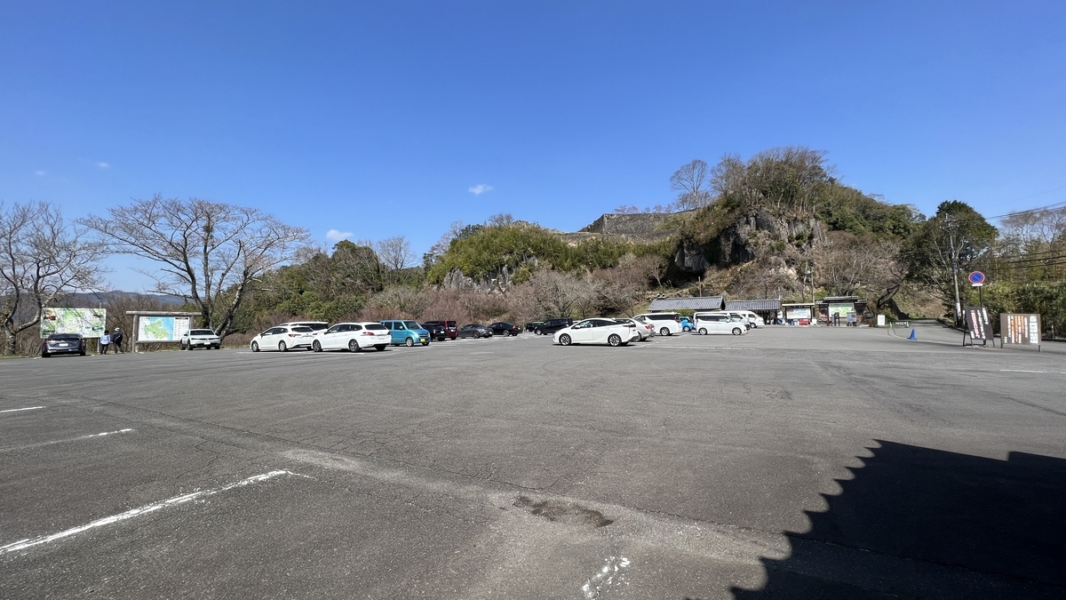 岡城跡駐車場の広場と奥に見える石垣の丘