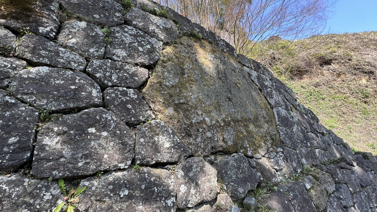 石垣に埋め込まれた巨大な鏡石と周囲の石積み