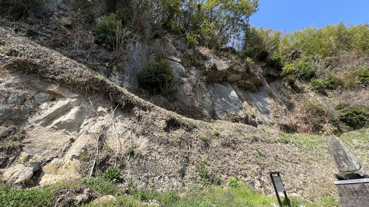 阿蘇溶結凝灰岩の崖と案内板が立つ斜面