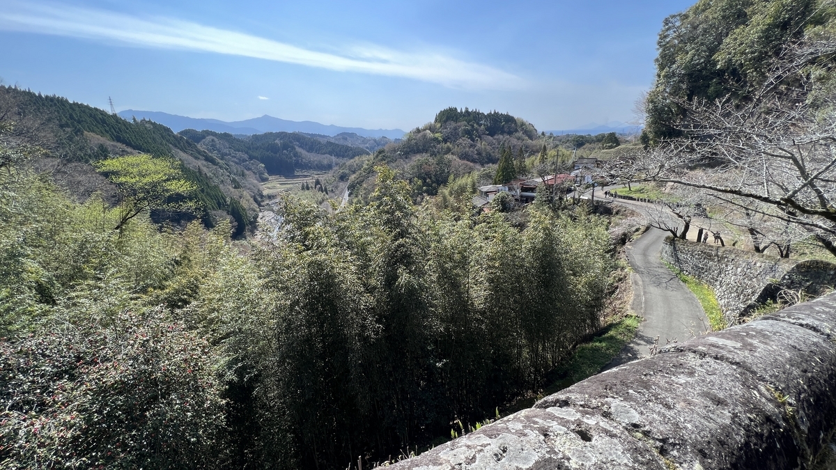 石垣越しに広がる渓谷と竹林の眺め