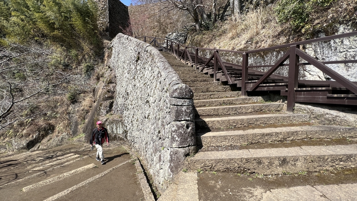 石垣沿いに続く長い階段と木製の手すり