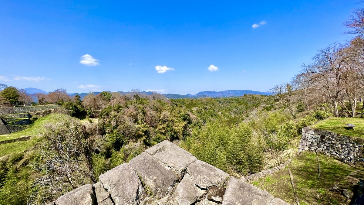 石垣の端から見渡す深い谷と遠い山々