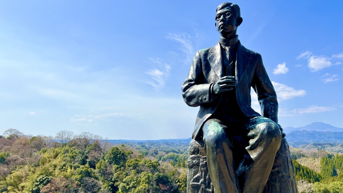 空を背景に立つ滝廉太郎像の上半身