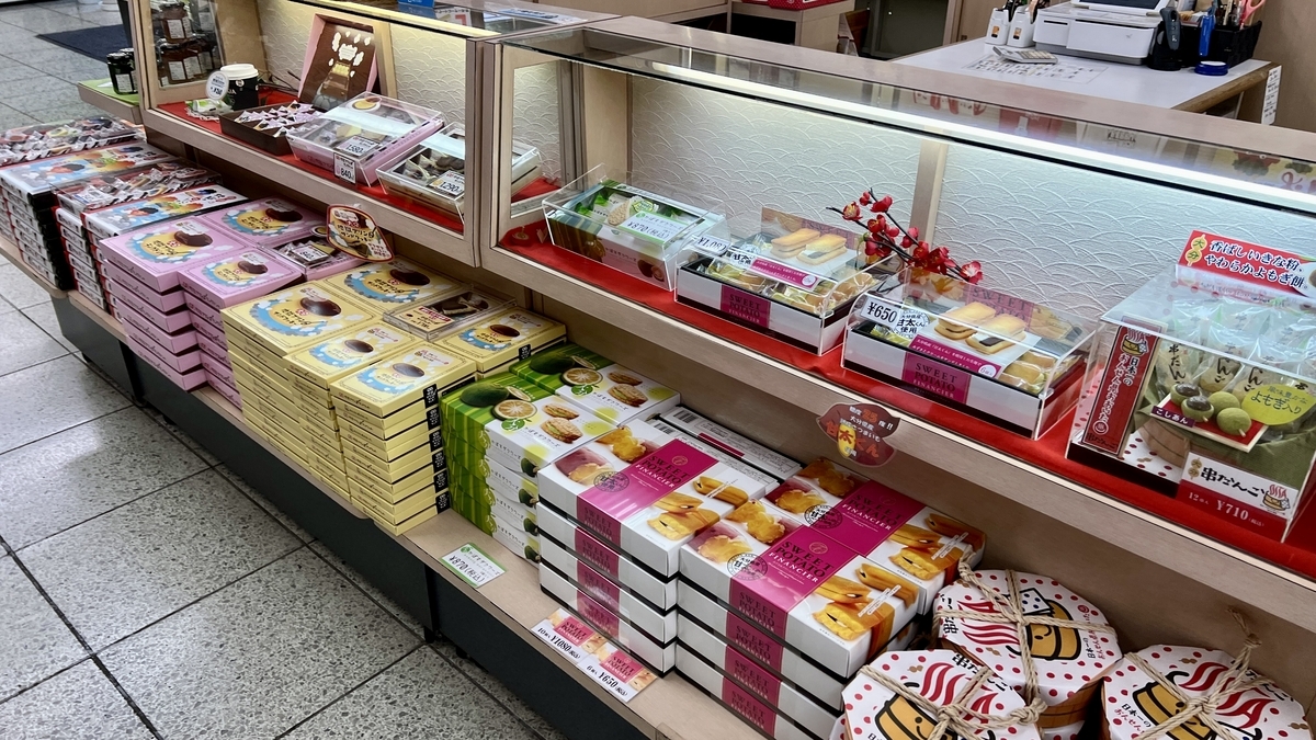 売店のガラスケースに並ぶ箱菓子と価格表示
