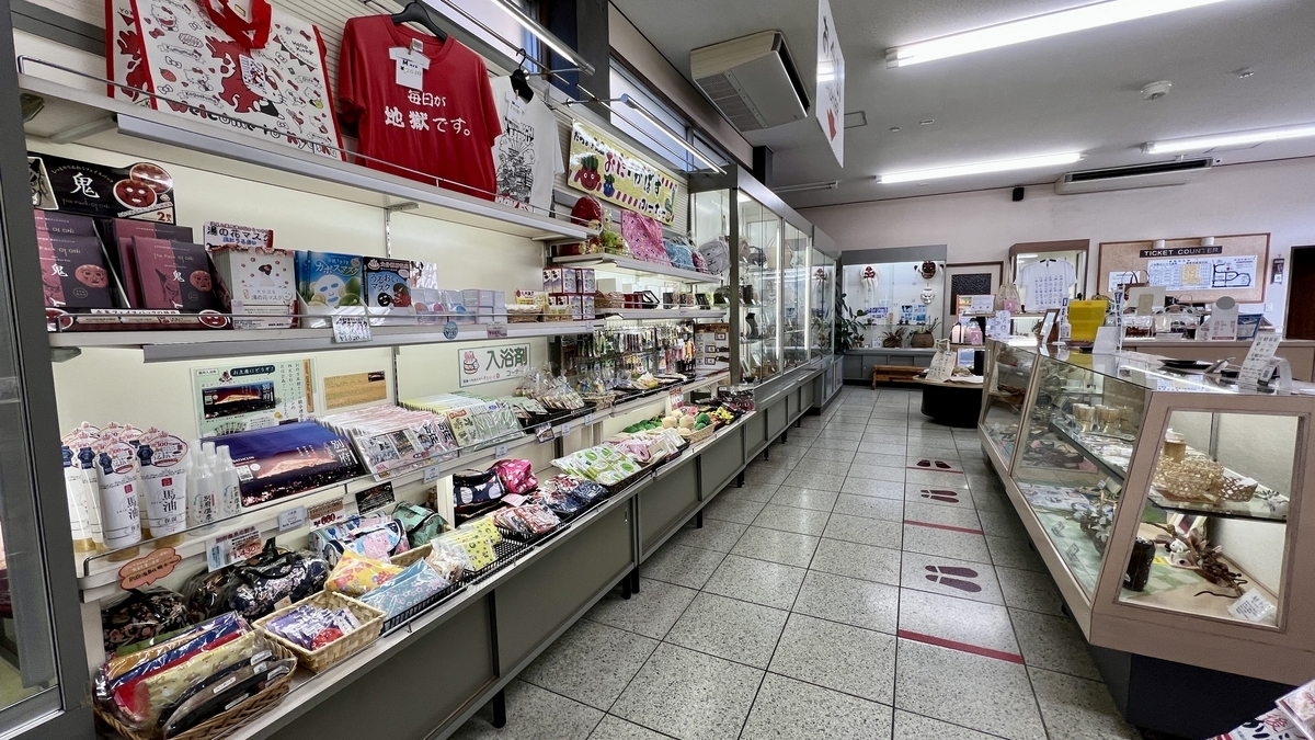 龍巻地獄の売店通路に並ぶ土産品棚とTシャツの売り場