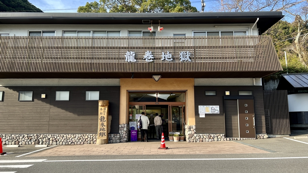 龍巻地獄の入口建物と木製の看板柱が立つ正面外観
