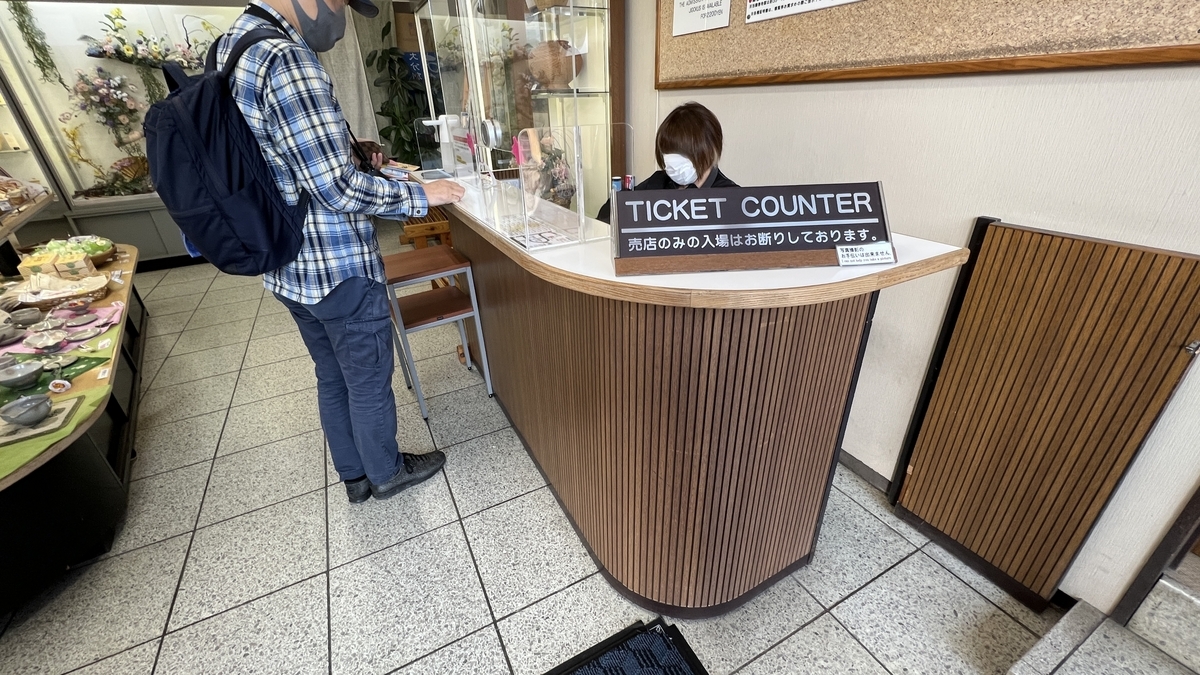 龍巻地獄の入場受付カウンターでチケットを購入する来場者
