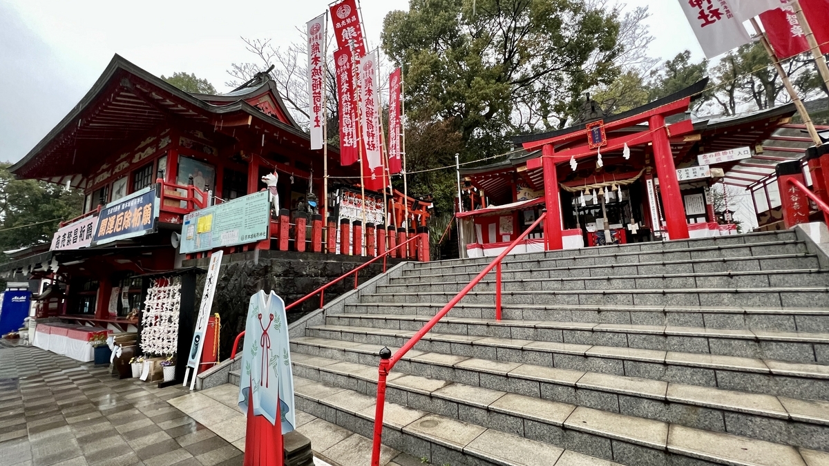 石段と朱色の手すりに囲まれた熊本城稲荷神社の本殿と社務所