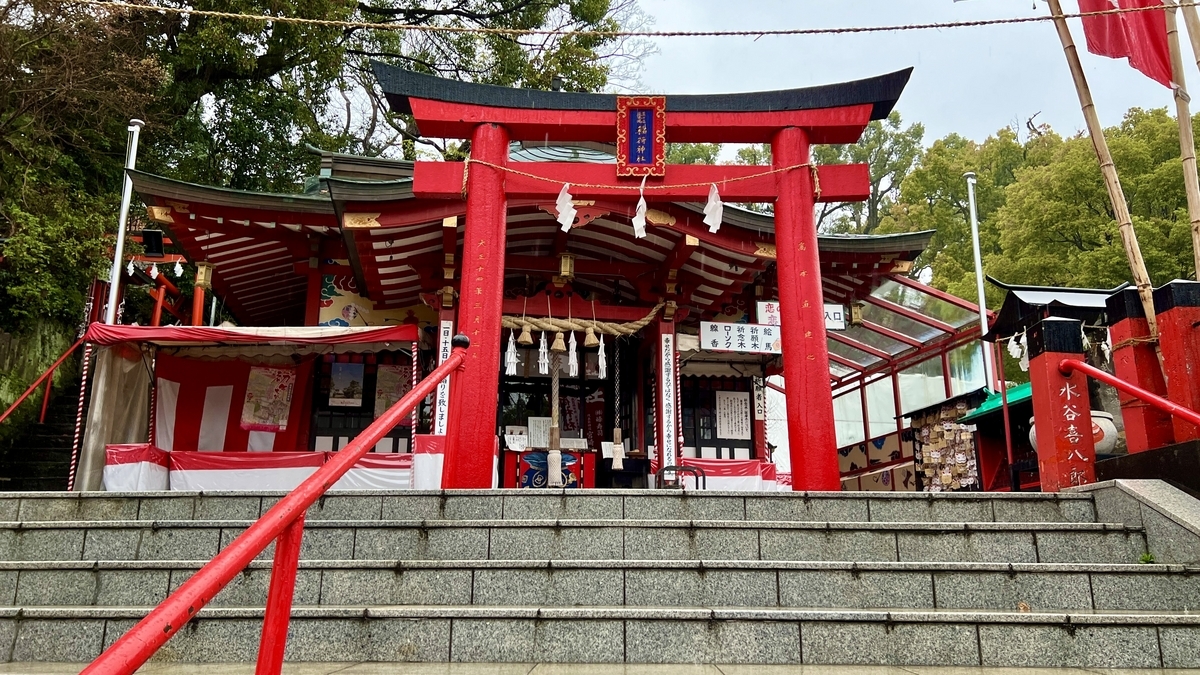 石段の上に立つ朱色の鳥居と本殿正面