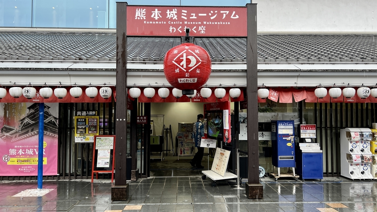 熊本城ミュージアムわくわく座の入口に掲げられた看板と赤い提灯と連なる白提灯