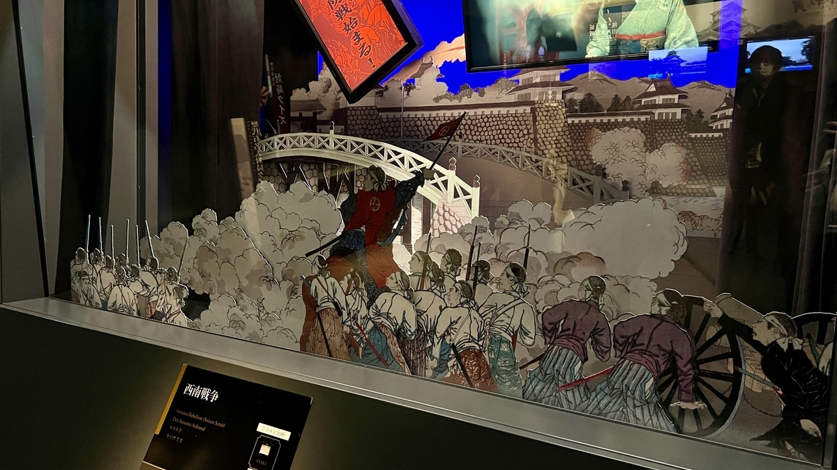 西南戦争の戦闘を描いた切り絵の兵士たちと橋や煙の立体展示