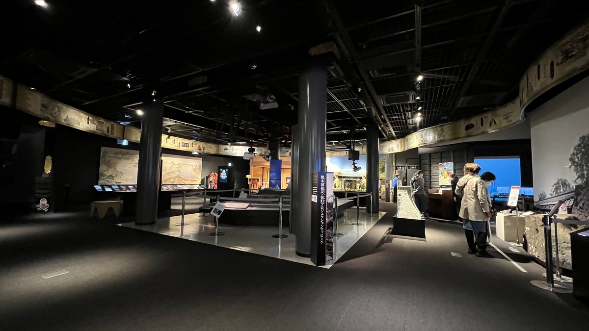 わくわく座の館内全景と展示パネルを見学する来館者