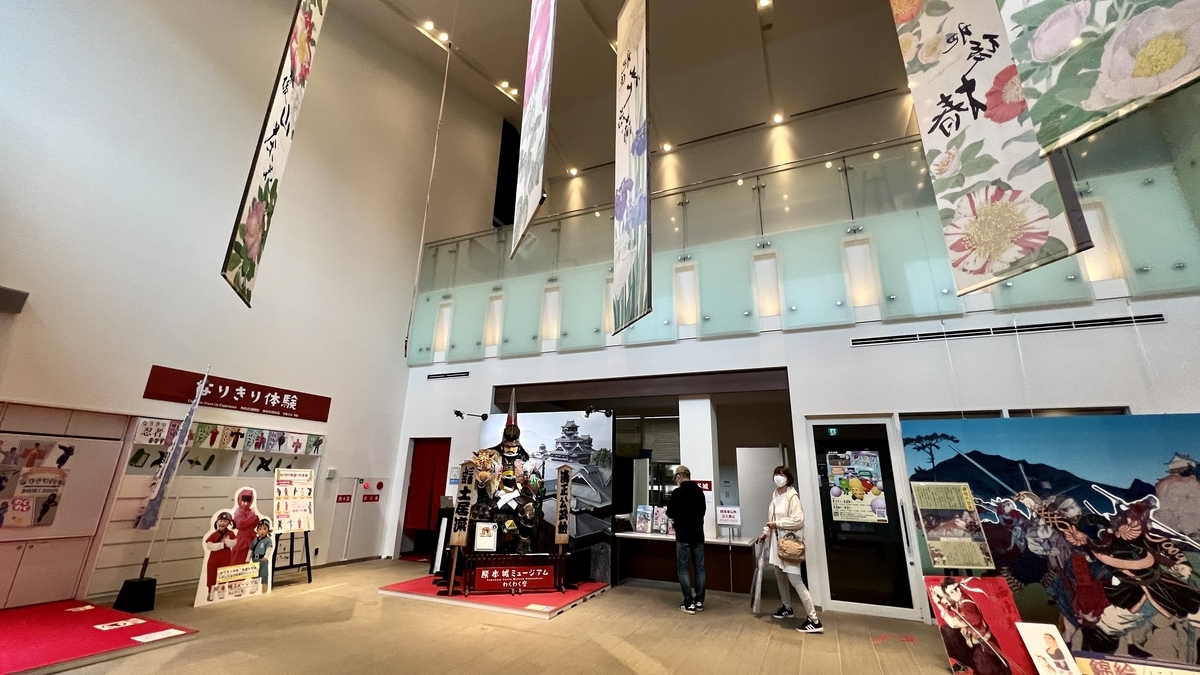 わくわく座のロビーで熊本城甲冑展示と受付カウンターが並ぶ空間