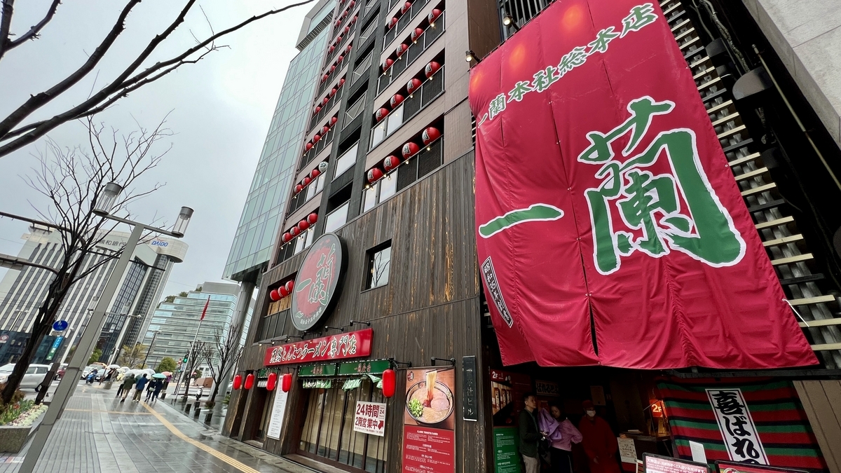 雨の日の一蘭本社総本店外観と巨大なのれんが目立つ街並み