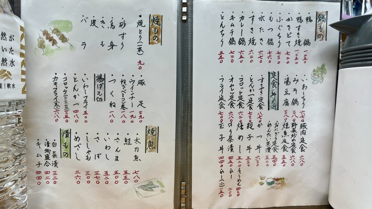 手書きの焼き鳥と焼魚と鍋物が載る見開きメニュー表