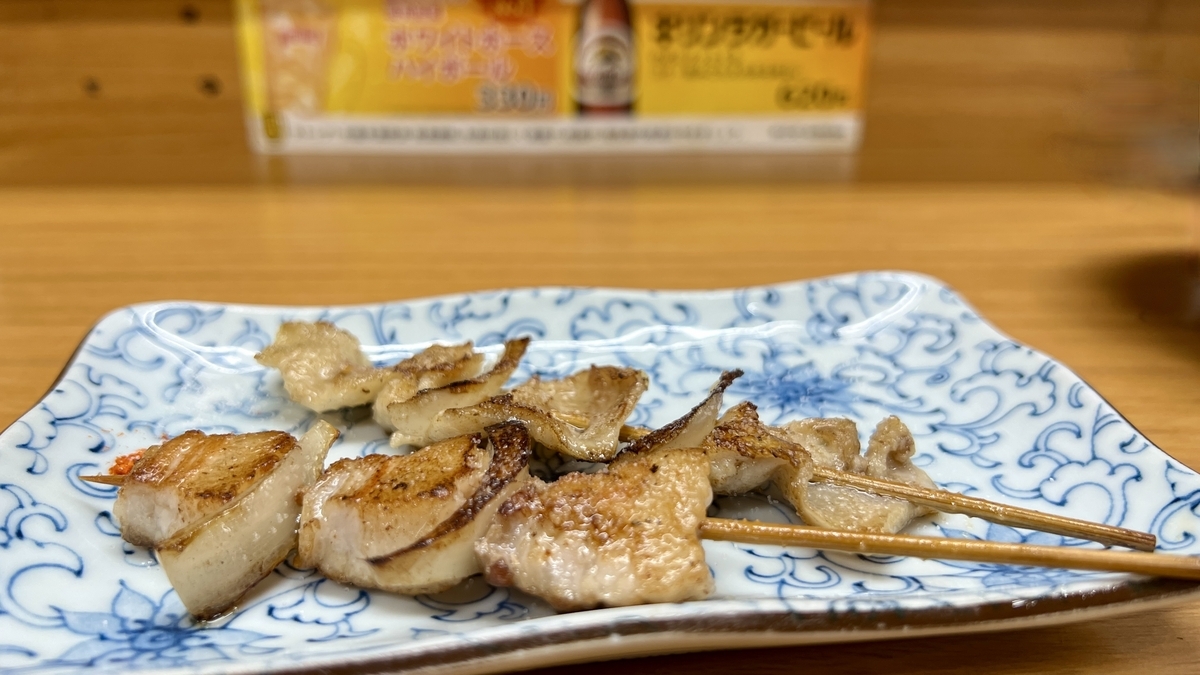 豚バラと皮の串焼きが盛られた青い模様の角皿