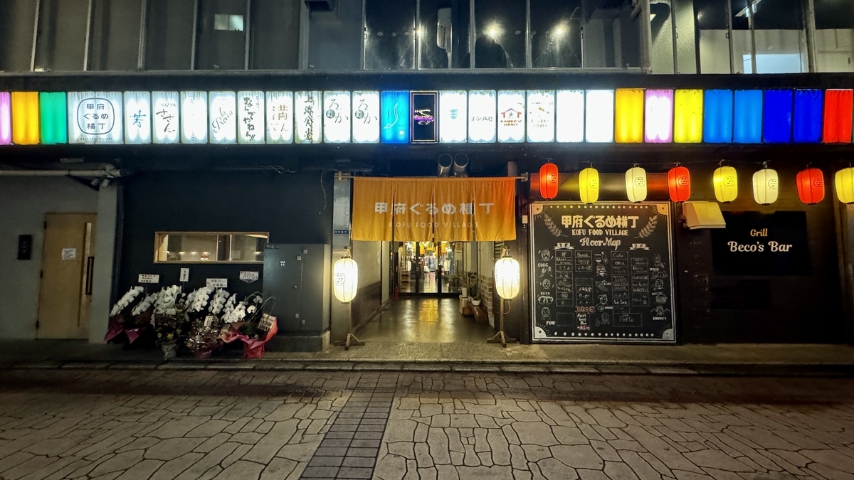 甲府ぐるめ横丁の外観で入口の暖簾と色とりどりの看板と提灯