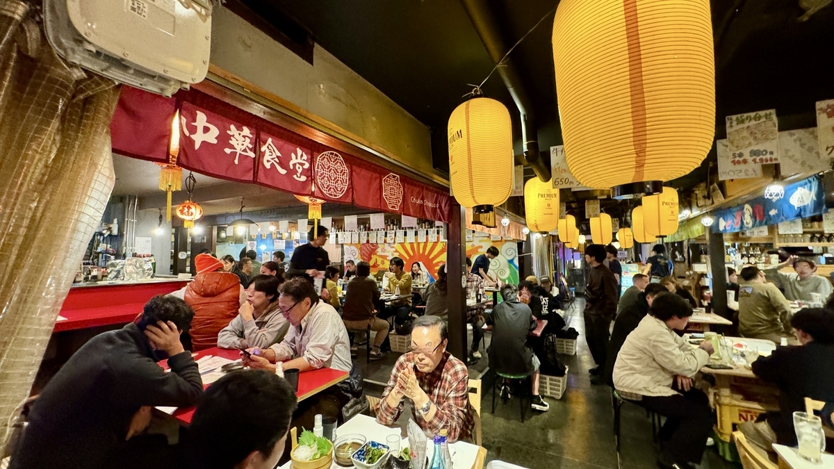 中華食堂ののれん下で食事を楽しむシェアエリアの客席