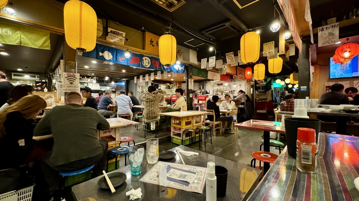 提灯が灯るシェアエリアで食事を楽しむ来店客