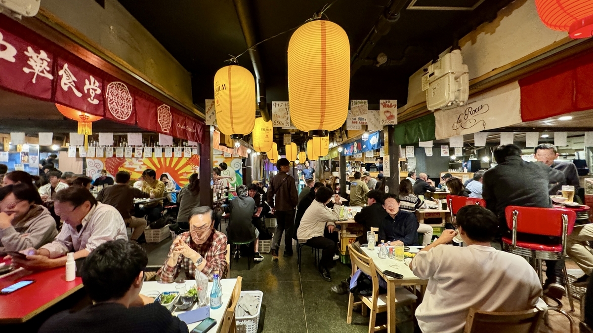 大型の提灯が並ぶシェアエリアで賑わう客席と各店ののれん