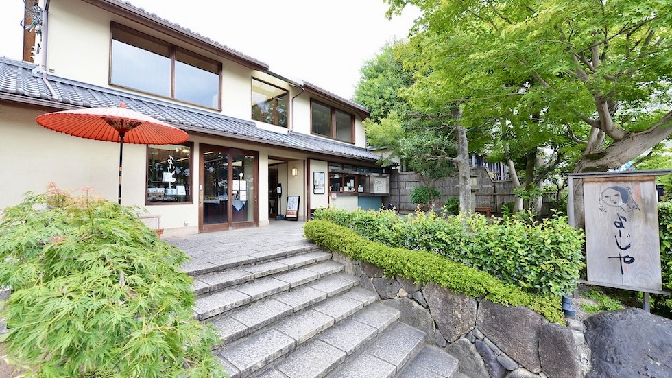 よーじやカフェ嵯峨野嵐山店の石段と赤い番傘が映える和風建物の外観